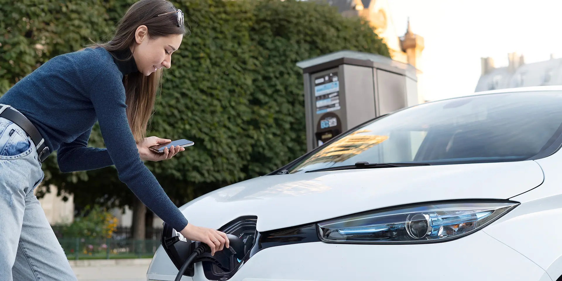 Frau tankt Strom in ihr E-Auto