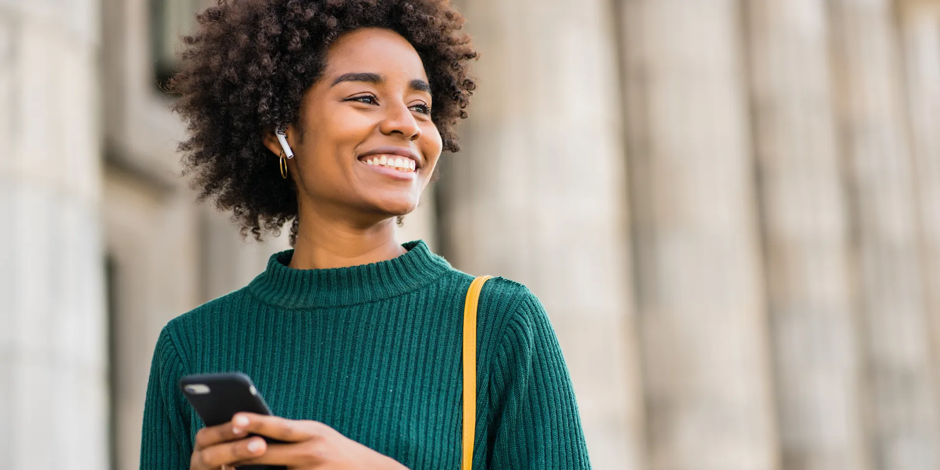 Junge Frau hört Musik via Bluetooth und lacht