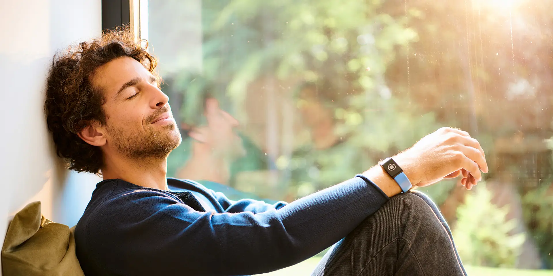 Man sits relaxed on a windowsill and enjoys the situation in the sun