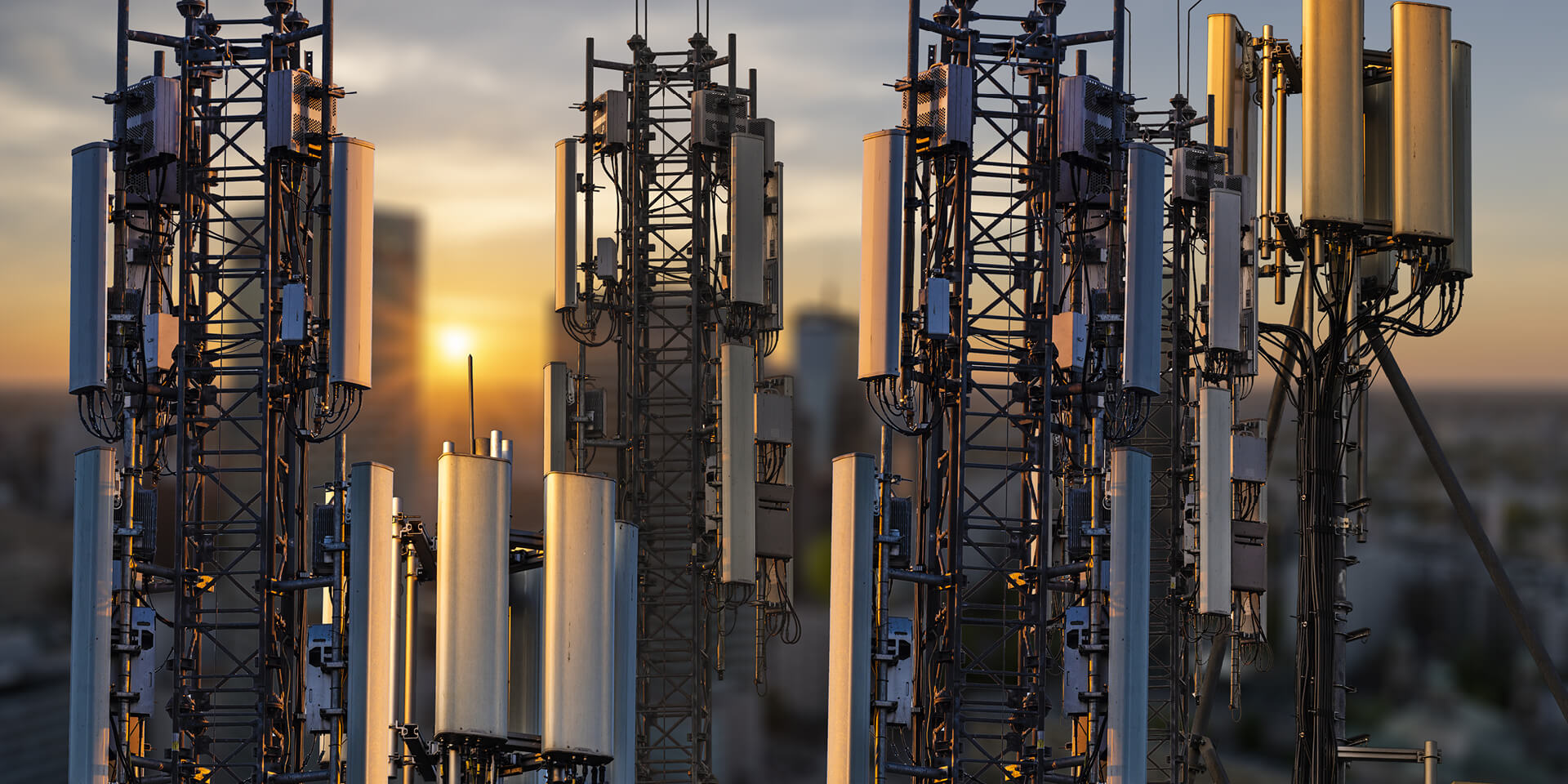 City with different transmission towers at sunset