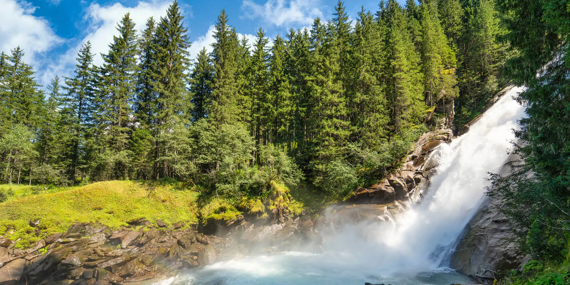 Natural waterfall surrounded by green trees in nature