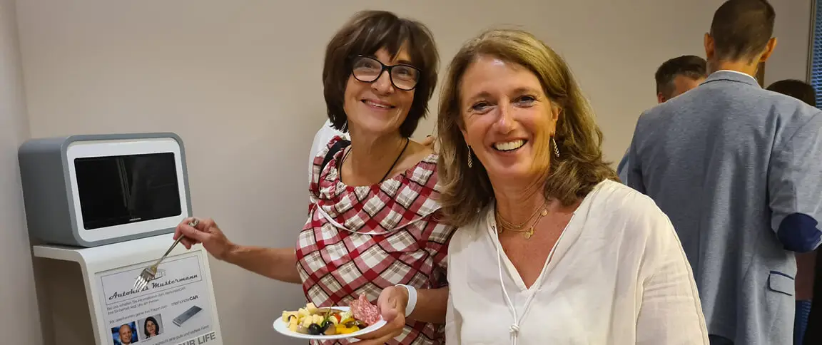 Two smiling women at the buffet looking into the camera