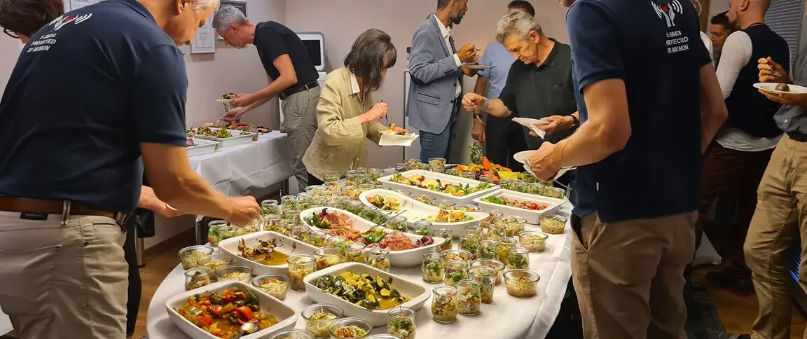 Seminarteilnehmer an einem Buffet am runden Tisch bei memon