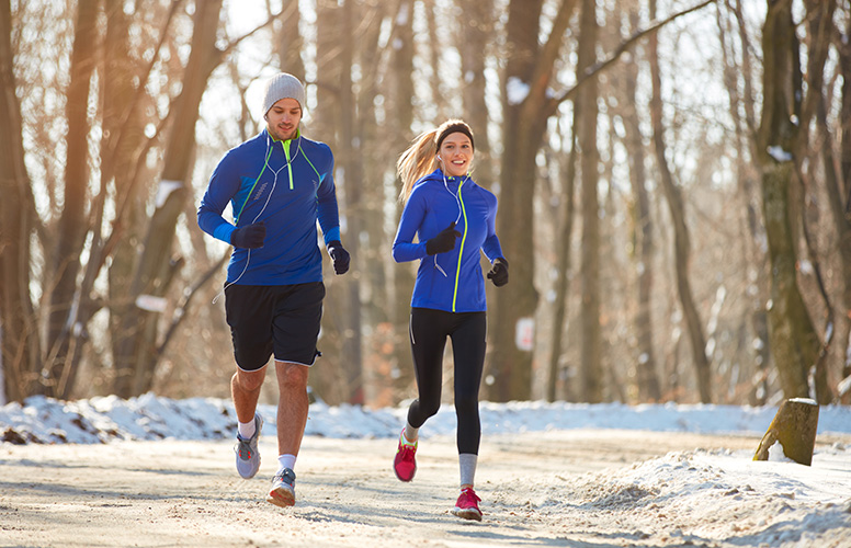 memon Sport Une joggeuse et un joggeur dans un parc enneigé