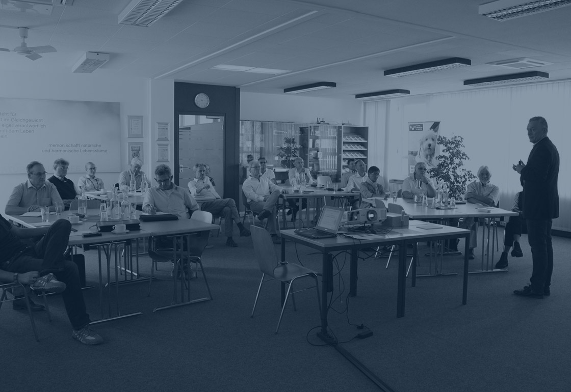 Séminaires memon Les participants au séminaire regardent une vidéo explicative memon sur l'écran d'une salle de conférence